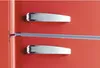 A close-up view of a red refrigerator door with two silver handles and a silver trim. Produktbild-Vorschau