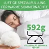 A woman sleeping under a white duvet, with a close-up of the filling material in the foreground. Produktbild-Vorschau