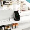 A close-up view of a vanity desk with integrated charging features, including a wireless charging pad with a phone, AC outlets, and USB ports. Makeup items are also visible on the shelf below. Anteprima dell’immagine prodotto