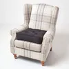 A wingback armchair with a plaid pattern and a dark grey cushion on the seat. Náhled obrázku produktu