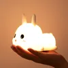 A hand holding a glowing bunny-shaped night light. Produktbild-Vorschau