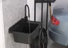 A sink in a garage next to a car tire and a car. Anteprima dell’immagine prodotto