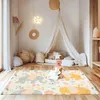 A baby playing on a colorful play mat in a nursery. Podgląd zdjęcia produktu