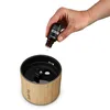 A hand is adding essential oil to an aroma diffuser. Produktbild-Vorschau