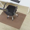 An office chair on a brown floor mat in front of a white desk. Podgląd zdjęcia produktu