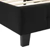 A close-up view of the corner of a black upholstered bed frame, showing the wooden slats of the bed base and a black wooden leg. Produktbild-Vorschau