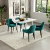 A dining set with a white table and four teal chairs on a fluffy white rug, set against a wood-paneled wall with framed artwork. Náhľad obrázku produktu