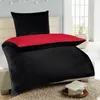 A bed with black and red bedding in a bedroom setting. Anteprima dell’immagine prodotto