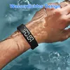 A person's wrist wearing a black fitness tracker smartwatch submerged in water. Produktbild-Vorschau
