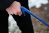 A person's hand holding a blue trash grabber. Anteprima dell’immagine prodotto