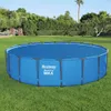 A round, blue swimming pool with a solar cover sits on a green lawn, surrounded by trees and bushes. Náhled obrázku produktu