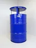 A blue barrel-shaped table with a metal top, standing in a corner against a white wall. Produktbild-Vorschau