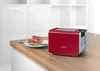 A red Bosch toaster sits on a wooden countertop next to a plate with toast and jam. Produktbild-Vorschau