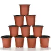 A pyramid stack of brown plastic plant pots with black rims, isolated on a white background. Produktbild-Vorschau