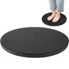 A black rotating disc with a person's feet standing on it, shown in the background. The main focus is the disc itself. Produktbild-Vorschau