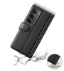 A black leather flip case for a smartphone is shown falling and impacting a cracked surface, illustrating its protective qualities. Produktbild-Vorschau