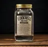 A bottle of O'Donnell Moonshine High Proof sits on a wooden surface against a dark background. Produktbild-Vorschau