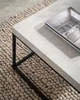 A close-up of a modern coffee table with a magazine on it, placed on a textured rug. Anteprima dell’immagine prodotto