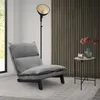 A modern living room scene with a gray floor chair, a floor lamp, and a side table with flowers. Podgląd zdjęcia produktu