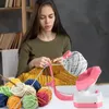 A woman is knitting, with a yarn winder in the foreground. Produktbild-Vorschau