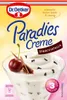 A dessert in a glass, garnished with a cherry and cinnamon sticks, on a gradient background. Voir les images du produit