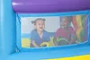 Two young children are inside a colorful inflatable bounce house, looking out through a mesh window. Voir les images du produit