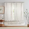 A window with sheer curtains, a side table with a lamp and plant, and a framed picture on the wall. Produktbild-Vorschau