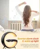 A woman waking up in bed with a sunrise alarm clock next to her. Produktbild-Vorschau