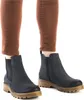 A close-up shot of a person's legs wearing brown pants and blue Chelsea boots. Produktbild-Vorschau