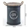 A dark gray laundry basket with a wooden lid and rope handles, featuring a circular graphic with text. Produktbild-Vorschau