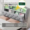 A bed with a headboard featuring integrated storage and lighting. Anteprima dell’immagine prodotto