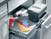 A drawer in a kitchen cabinet is pulled out, revealing cleaning supplies and a trash bin. Anteprima dell’immagine prodotto