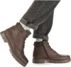 A person wearing brown leather boots and cuffed jeans. Produktbild-Vorschau