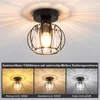A ceiling light fixture with a black metal frame and clear crystal accents, shown in three different light color temperatures. Náhled obrázku produktu