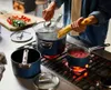 A person is cooking pasta and sauce on a stovetop. Anteprima dell’immagine prodotto