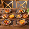 A beautifully set dining table with a full set of dishes, featuring colorful bohemian-style patterns, laden with various dishes and cutlery. Náhled obrázku produktu