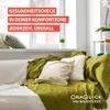 A couch with pillows and blankets in a room with a window. Produktbild-Vorschau
