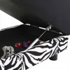 A close-up view of an open storage ottoman with a zebra print exterior, showing a few small toys inside. Produktbild-Vorschau