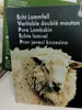 A close-up of a sheep's head with a product tag in the foreground. Produktbild-Vorschau