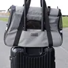 A gray pet carrier bag is placed on top of a black suitcase. Náhled obrázku produktu