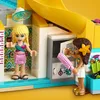 Two LEGO Friends characters are playing at a pool party, one is holding a small item and the other is holding a pink hairbrush. Produktbild-Vorschau