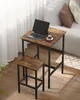 A laptop and coffee cup on a small, rustic-style bar table with a matching stool, next to a couch in a living room. Náhled obrázku produktu