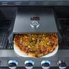A pizza oven attachment is placed on a grill, with a pizza inside. Produktbild-Vorschau