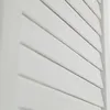 A close-up, detailed view of white wooden louvers. Produktbild-Vorschau