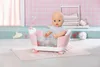 A baby doll sits in a pink and white bathtub with a transparent section showing colorful decorations. Produktbild-Vorschau