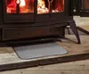 A hearth mat in front of a wood-burning stove. Produktbild-Vorschau