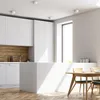 A modern kitchen with white cabinets, a wooden backsplash, and a white kitchen island, with a dining table and chairs in the foreground. Produktbild-Vorschau