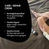 A person applying cream to their leg with a tube of cream visible. Produktbild-Vorschau