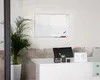 A whiteboard mounted on a wall above a desk with office supplies. Náhled obrázku produktu