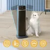 A white cat sits next to a black oscillating heater in a room. Anteprima dell’immagine prodotto